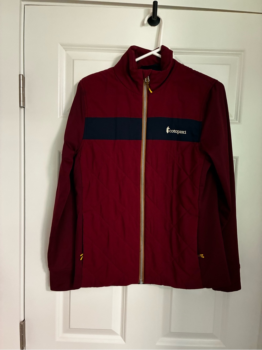 cotopaxi Maroon Jacket with Navy Chest Stripe and Yellow Zipper